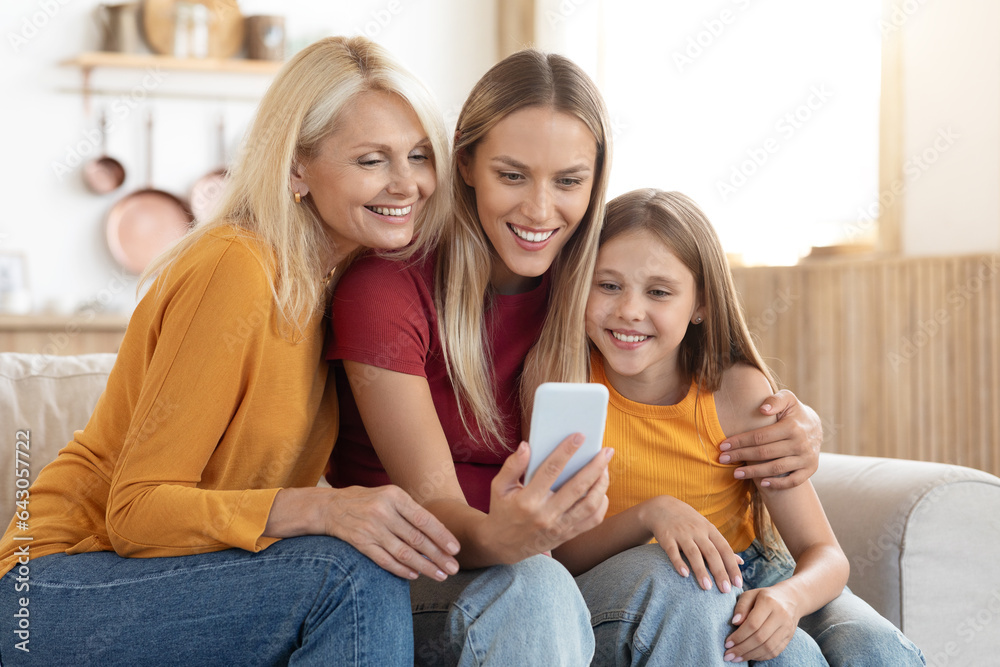 Happy family mother, daughter and grandmother using smartphone at home Happy family mother, daughter and grandmother using smartphone at home
