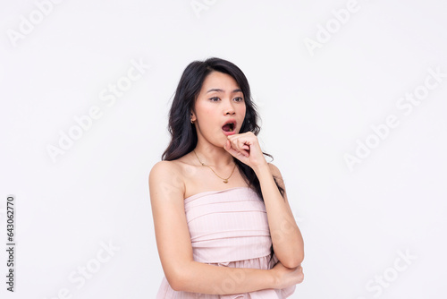 A young asian woman burping, gesturing with hand. Isolated on a white background.