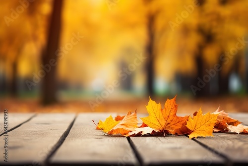 Beautiful orange maple leaves on a wooden table in the autumn park. Natural autumn background.