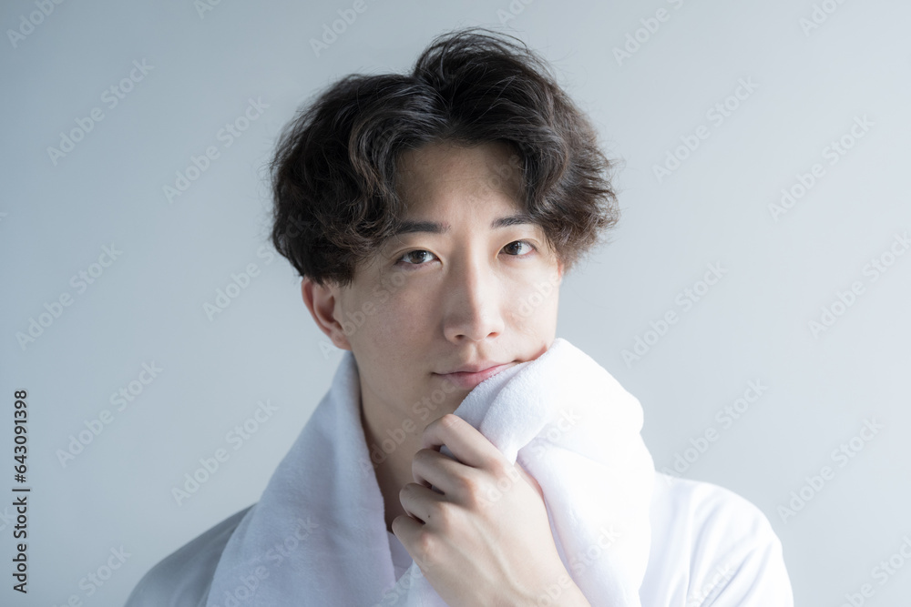 Handsome camera-ready man wiping his face with a towel Image of training and face washing Handsome camera-ready man wiping his face with a towel Image of training and face washing