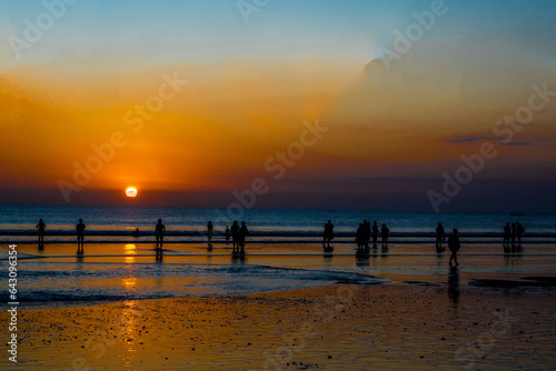 The silhouette of people engaged in activities  enjoying the sunset on Kuta Beach in Bali.