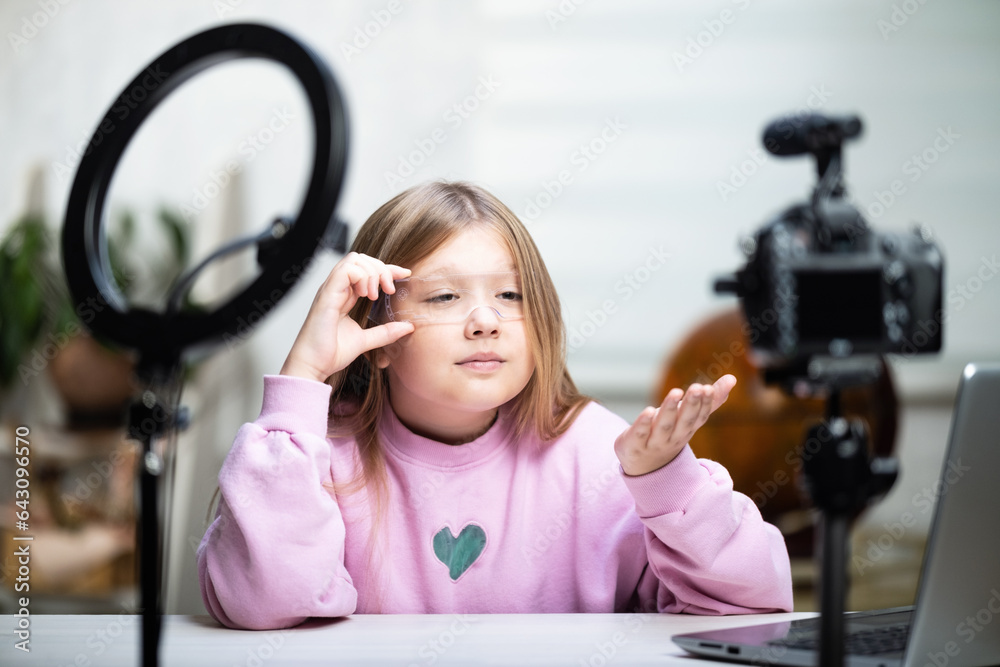 A beautiful blonde teenager is broadcasting live. The video blogger has a live broadcast. An annular lamp and a camera during a live broadcast of a video blogger A beautiful blonde teenager is broadcasting live. The video blogger has a live broadcast. An annular lamp and a camera during a live broadcast of a video blogger