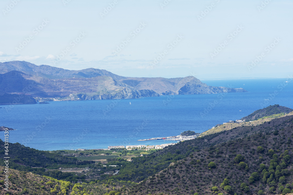 Panoramic coastal view from above, with waves and boats from coastline