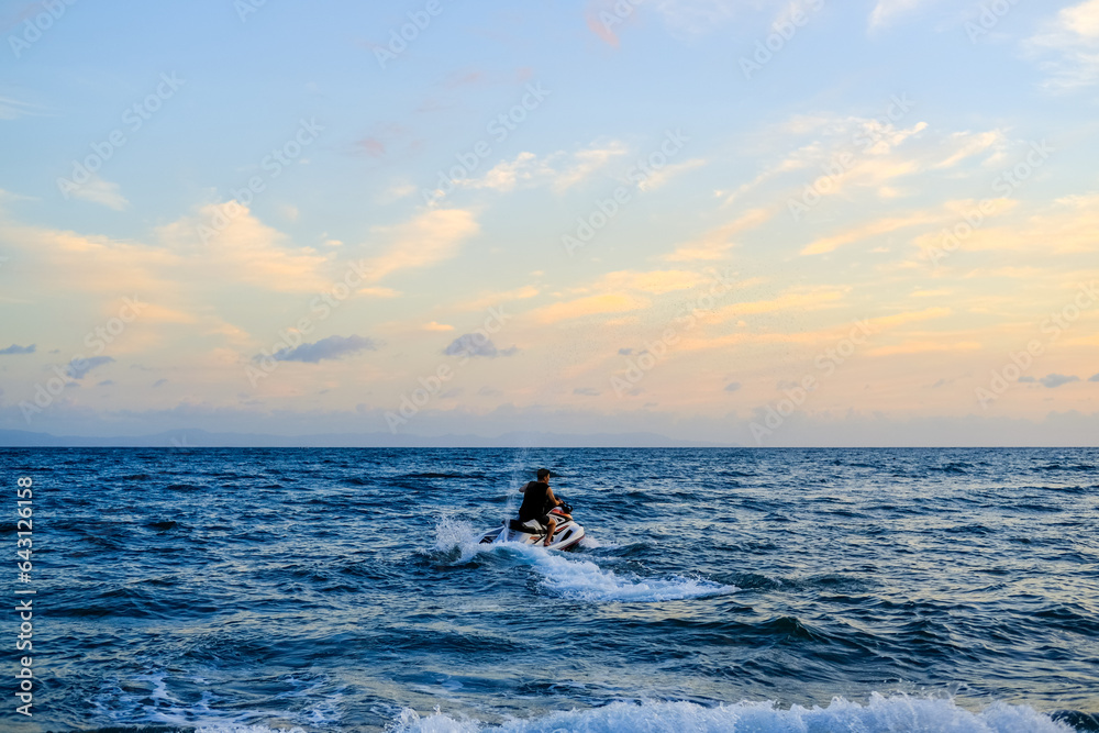 Fototapeta premium ride a jet ski on the beach, sunset over the sea, sunset in the sea, sea and sky, sunset over sea, beautiful sunset sky, blue and orange sky, sunset wallpaper