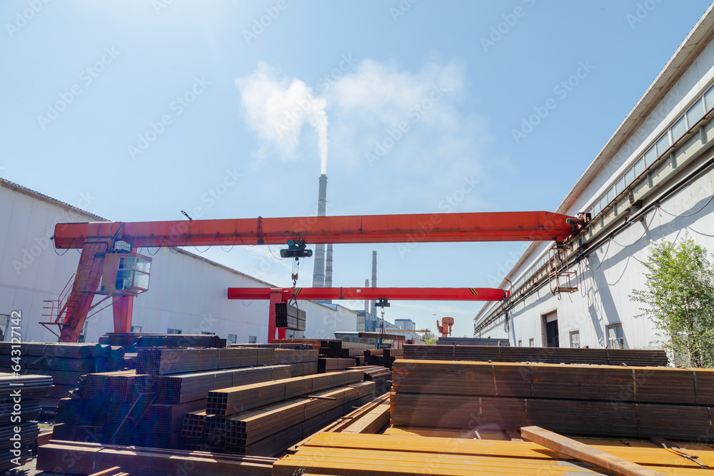 Worker transporting stack of metal pipes with gantry crane Worker transporting stack of metal pipes with gantry crane