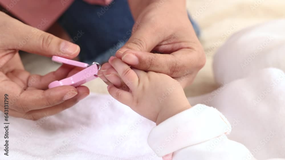 Happy mother hand holding clipper cutting newborn baby nails on tiny fingers while adorable infant sleeping, close-up keep clean and safe from face scratching and diesease, Healthy Family Parenthood Happy mother hand holding clipper cutting newborn baby nails on tiny fingers while adorable infant sleeping, close-up keep clean and safe from face scratching and diesease, Healthy Family Parenthood