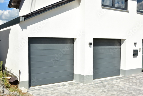 Moderne Einbau-Garage mit grauem Automatik-Rolltor eines modernen Einfamilienhaus