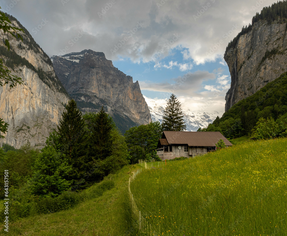 Buildings Sitting Along the Hills high up in the Swiss Alps with mountains in the background in Switzerland in Summer Buildings Sitting Along the Hills high up in the Swiss Alps with mountains in the background in Switzerland in Summer