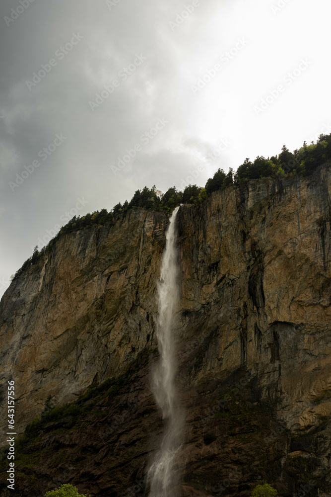 Fototapeta premium Close Up View of a Waterfall in the Swiss Alps with mountains in the background in Switzerland in Summer
