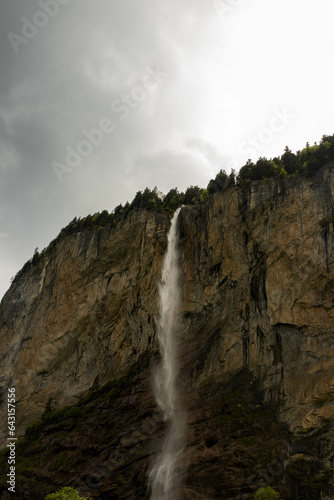 Close Up View of a Waterfall in the Swiss Alps with mountains in the background in Switzerland in Summer