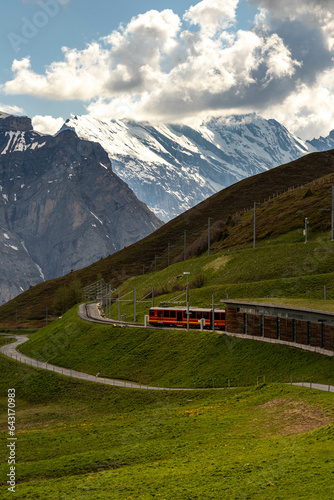 Train Traveling Up the Mountain in the Swiss Alps in the Summer with Mountains in the Background in Switzerland