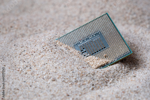 CPU or Micro Processor Unit on the sand. Semiconductor component buried in the ground.  photo