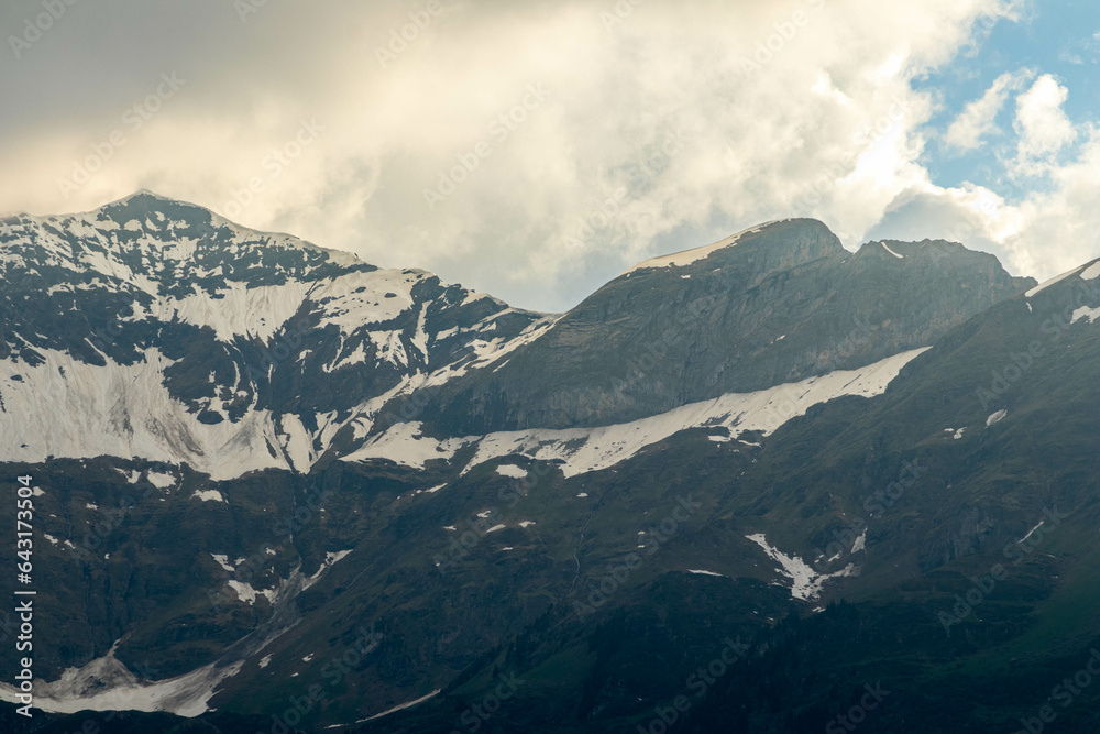 Close Ups of Mountains of the Swiss Alps in Switzerland in the Summer at Sunset with the Mountains Peaking Through Clouds