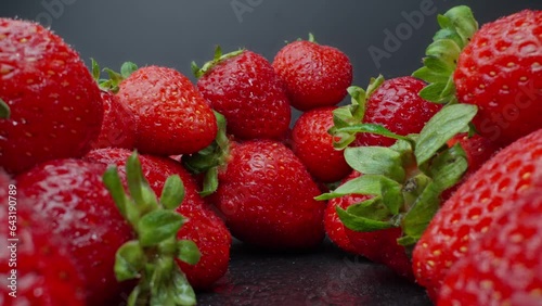 Ripe juicy strawberry. Healthy organic food. Fresh strawberries. Camera moving through heap of strawberries. Dolly shot using probe lens. Slide out. Red berries. Close-up in 4K, UHD