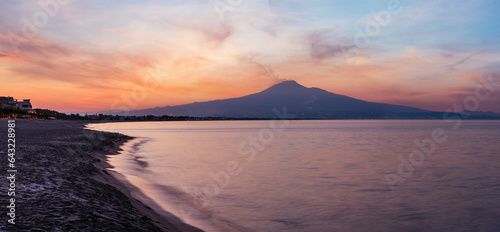 Fototapeta Naklejka Na Ścianę i Meble -  Beautiful sunset twilight on Agnone Bagni sea beach with smoky Etna volcano in far (Siracusa, Sicily, Italy). 