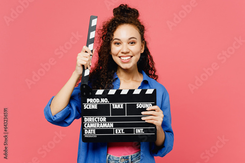 Photo Young fun woman of African American ethnicity she wear blue shirt casual clothes hold in hand classic black film making clapperboard isolated on plain pastel pink background studio