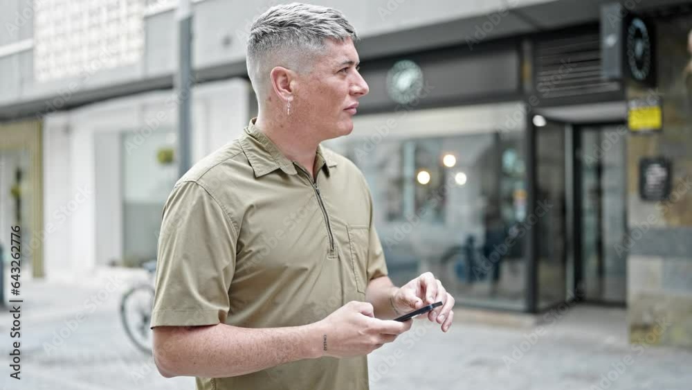 Young caucasian man using smartphone with serious expression at street Young caucasian man using smartphone with serious expression at street