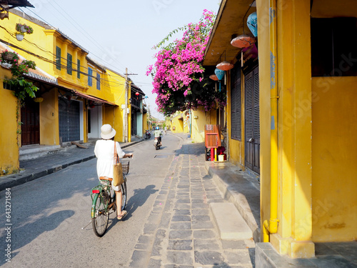 Woman riding a bicycle on the streets of Hoi An on a beautiful morning photo
