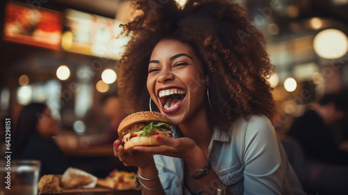 Young American african woman eating burger enjoying her life in the cafe  Hamburger  fast food  brunch in restaurant lunch meal craving deal