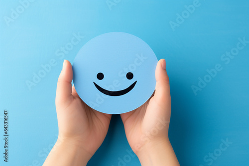promoting positive mental health hand holding paper smiley. High quality photo