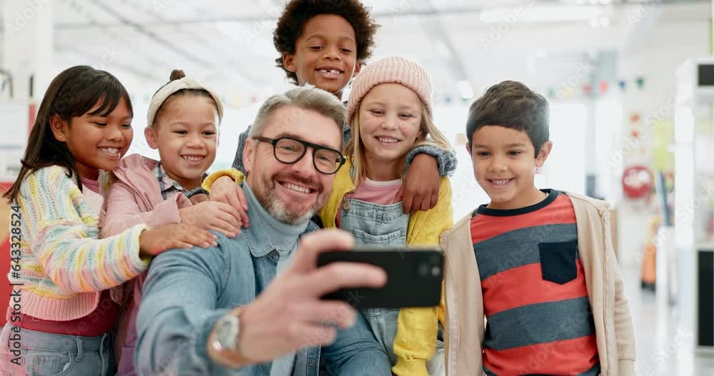 Teacher man, selfie and school kids with smile, classroom and happy with diversity, group and memory. Education, learning and mentor with photography, friends and development on social network app Teacher man, selfie and school kids with smile, classroom and happy with diversity, group and memory. Education, learning and mentor with photography, friends and development on social network app