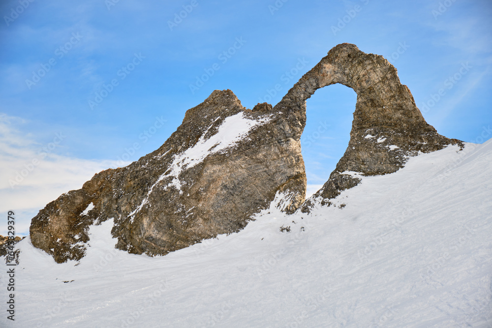 Aiguille Percee viewpoint in Winter, a popular rock formation with a hole in the middle in Tignes ski resort, France.