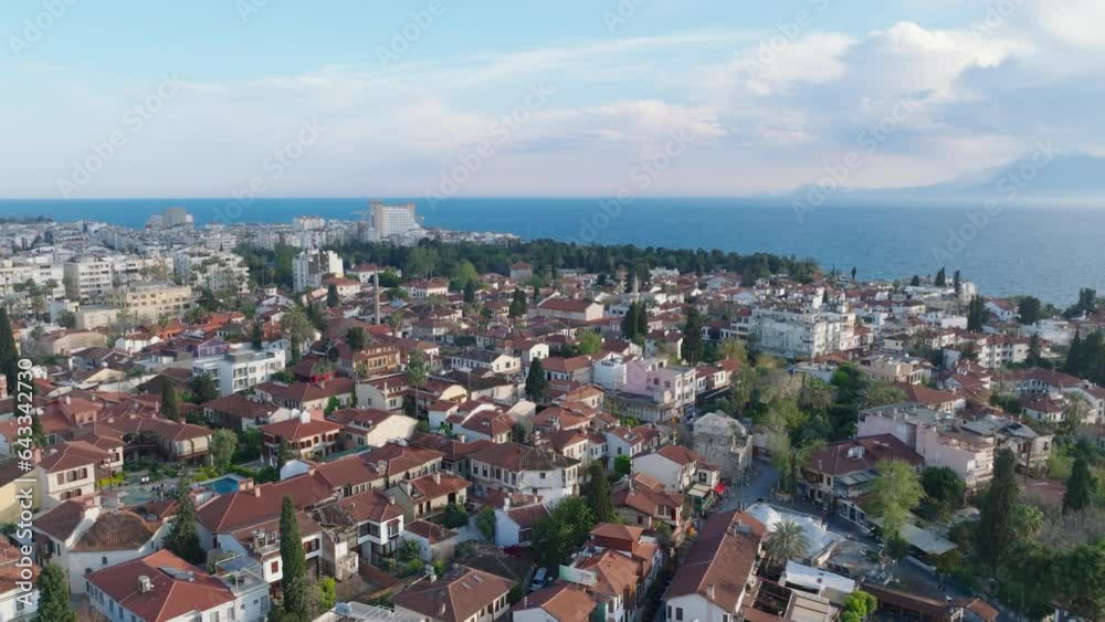 Forwards fly above buildings in old town at golden hour. Traditional houses and mosque with minarets in city centre near sea coast. Antalya, Turkey Forwards fly above buildings in old town at golden hour. Traditional houses and mosque with minarets in city centre near sea coast. Antalya, Turkey