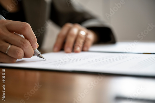 Closeup view of female hands signing a document or contract