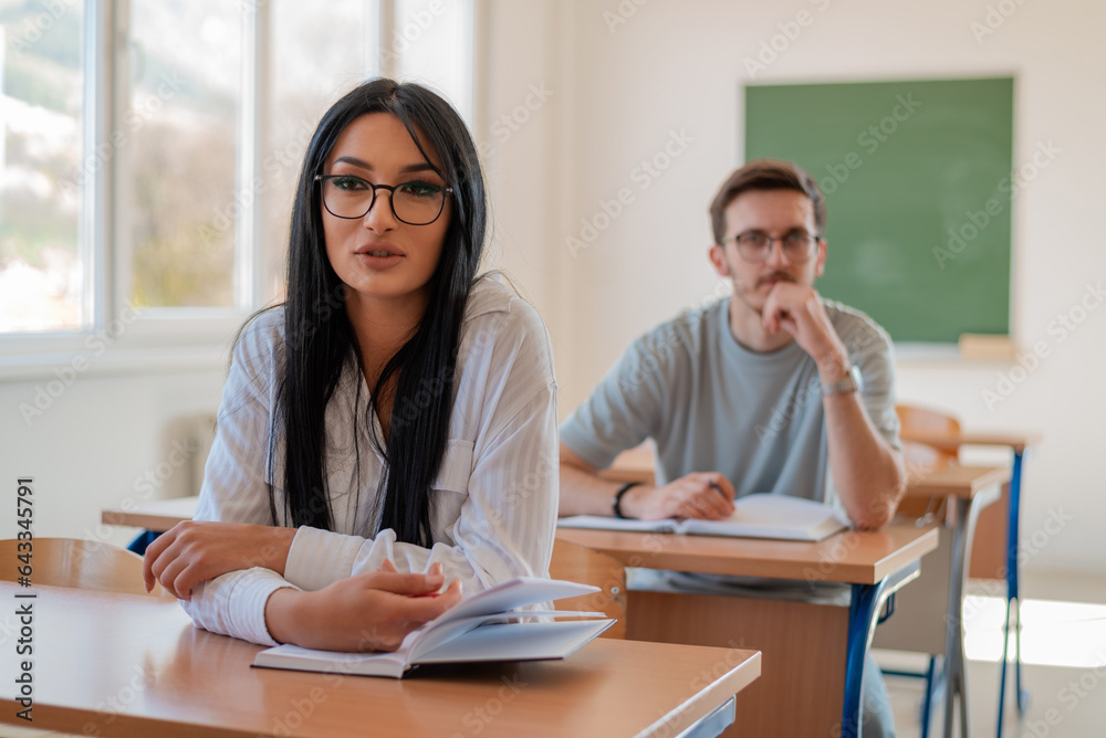 In the classroom group of college students are listening to a lecturer and are involved in the discussion. In the classroom group of college students are listening to a lecturer and are involved in the discussion.