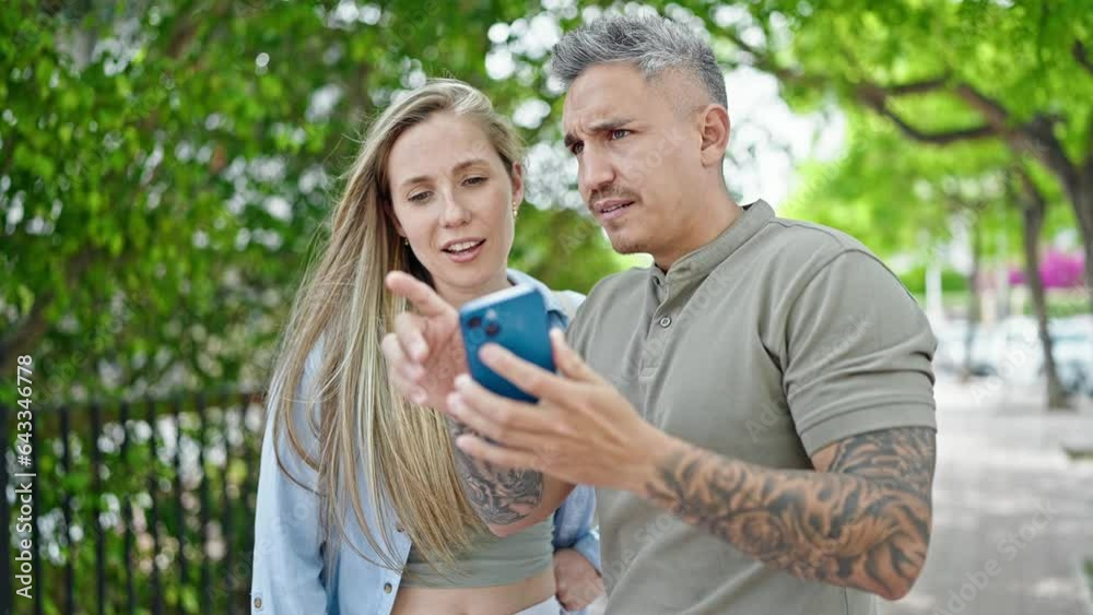 Man and woman couple smiling confident using smartphone at park Man and woman couple smiling confident using smartphone at park