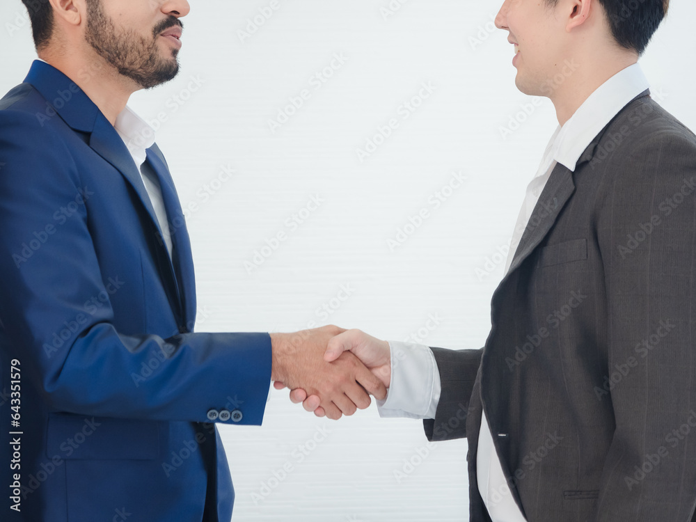 Portrait business manager team man handsome smart Asian two people group standing on wall white looking shake hand within the agreement ready for happy working online creative sale inside home office Portrait business manager team man handsome smart Asian two people group standing on wall white looking shake hand within the agreement ready for happy working online creative sale inside home office