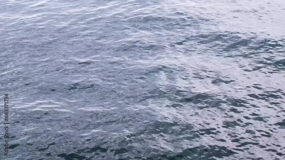 Continuously changing disquiet blue sea or ocean surface for a background. Beautiful and fresh wavy water on a cloudy spring afternoon. Refreshing, abstract and minimalistic 4K slow motion.