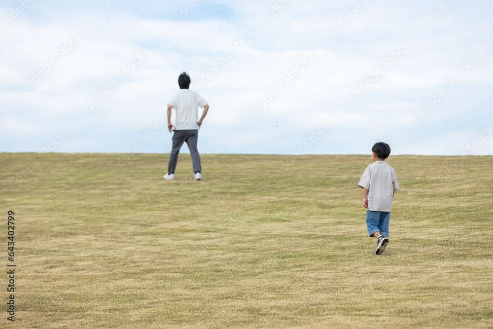 丘の上を歩く親子　Parent and child walking on the hill