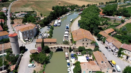 Drone shot, drone video, drone flight, aerial view, flight at low altitude over the Canal du Midi near Le Somail with a wide view over the landscape, camper site, boats and ships on the water photo