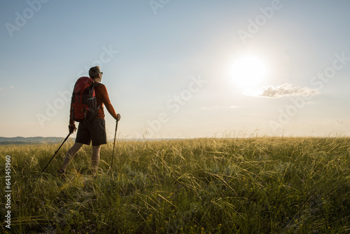 Man hiking at sunset. Travel lifestyle wanderlust adventure concept summer vacations outdoor.