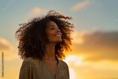 Young woman looking up at the sky at sunset