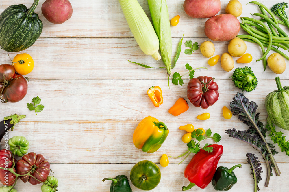 Seasonal vegetables, corn, potatoes, tomatoes, various peppers on a wooden background with a place for text Seasonal vegetables, corn, potatoes, tomatoes, various peppers on a wooden background with a place for text