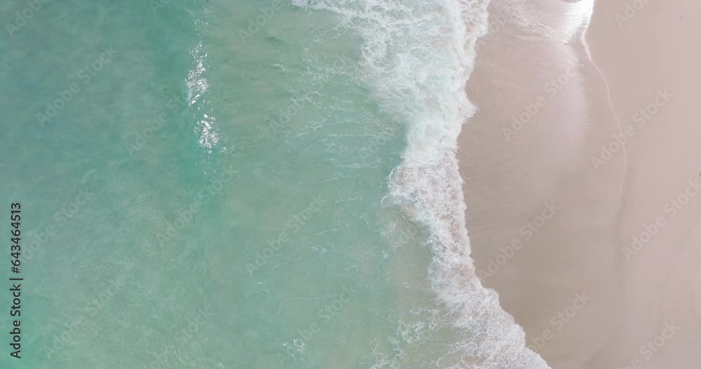 4K DCI 4096x2160p. Top-down view aerial beach video Ocean waves roll onto the beautiful beach. Filmed with high quality cinema cameras. DCI 4K ProRes422
