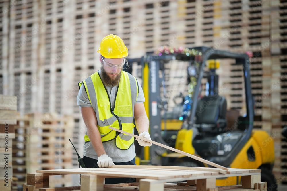 Warehouse worker working at lumber yard in Large Warehouse. Worker are  Inventory check at Storage shelves in lumberyard.