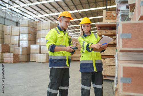 Woman with checklist in a timber and lumber warehouse. Product acceptance and quality control