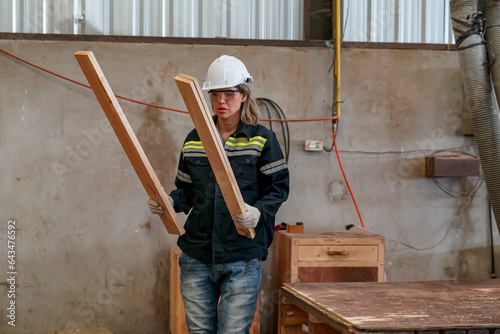 Worker are working at lumber yard in Large Warehouse. Worker are  working.on woodworking machine, lumber and Inventory check at Storage shelves in lumberyard. © FotoArtist