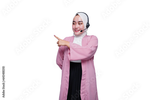 Smiling asian hijab girl customer service pointing at the blank space 