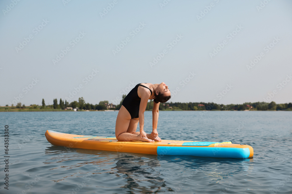 Woman practicing yoga on SUP board on river Woman practicing yoga on SUP board on river