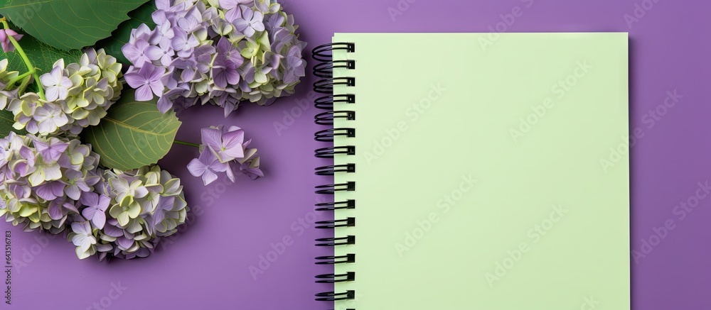 Purple background with dried hydrangea flowers on a green spiral notebook Copy space Purple background with dried hydrangea flowers on a green spiral notebook Copy space
