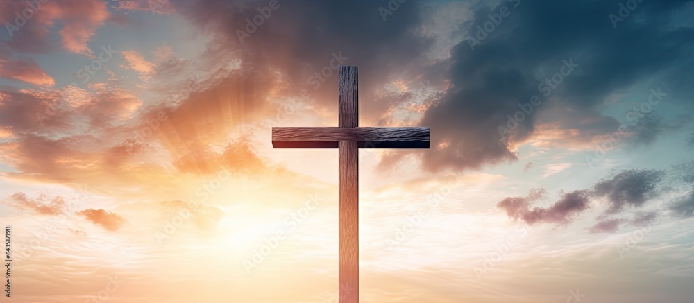 Digital composite of a wooden cross with cloudy sunset sky representing Ascension day and Christian beliefs