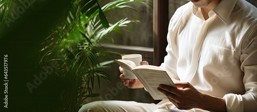 Asian man reading a book wi...