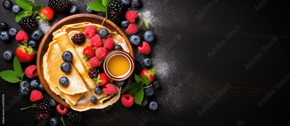 Fruity pancakes with honey on a dark background