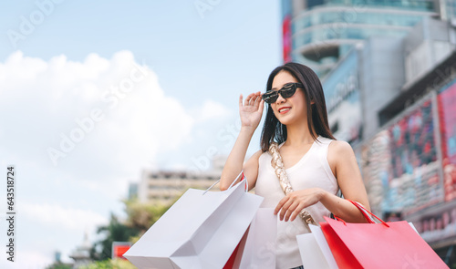 Asian woman shopping bags wear sunglasses lifestyles with buying consumerism at outdoor department store