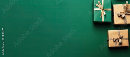 Christmas card with red gift boxes on green background arranged in a flat lay top view and text space