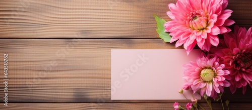 Colorful note paper with a pink flower and the words Thank you set against a wooden background
